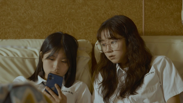 허쉬와 젤리가 나란히 소파에 누워 있다. 허쉬는 자신의 휴대전화를 바라보고 있고, 젤리는 허쉬의 휴대전화를 옆에서 본다.